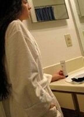 Une pute brune délicate affiche ses énormes seins à l'intérieur de Bathro