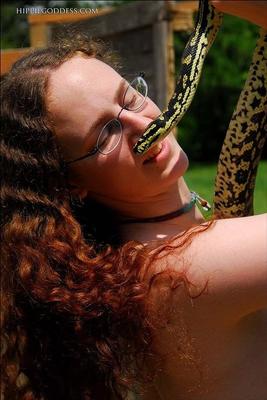 Hairy Hippie Girl Playing With Her Snake in the Garden
