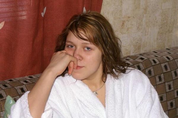 Беременная женщина села на стул у окна после душа
