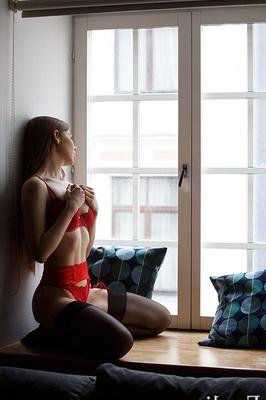 Evelina en la ventana en lencería roja