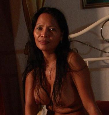 Une asiatique mature aux gros seins huile son corps et écarte les jambes